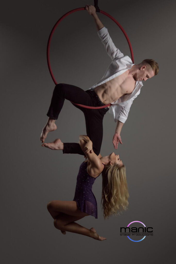 Aerial Duo hanging from an aerial hoop together with the look of love